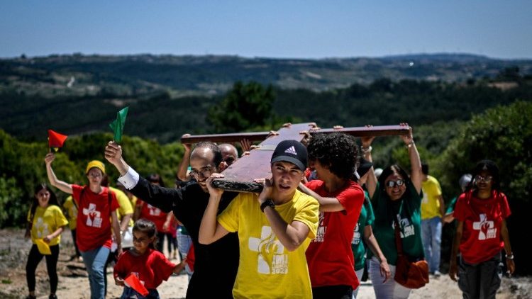 Pilgrims carry the World Youth Day Cross