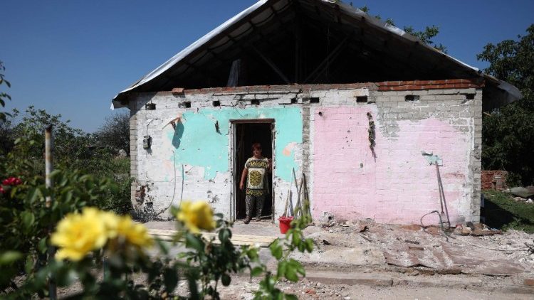 Uma residente local Valentina Ostapenko observa de sua casa danificada na vila de Topol's'ke, região de Kharkiv, em 5 de agosto de 2023, em meio à invasão russa na Ucrânia. (Foto de Anatolii Stepanov / AFP)