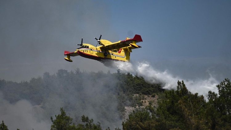 A Canadair drops water over wildfires in northern Greece