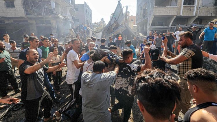 Palestinians retrieve a body from rubble of a building after an Israeli strike in Khan Yunis