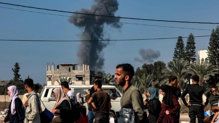 Smoke from Israeli bombardment rises behind people fleeing Gaza City
