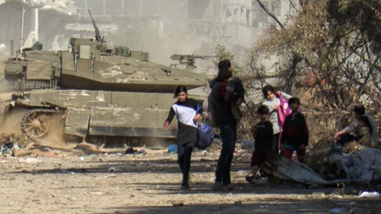 Palestinians fleeing Gaza City on foot as an Israeli armoured vehicle drives past them amid ongoing battles