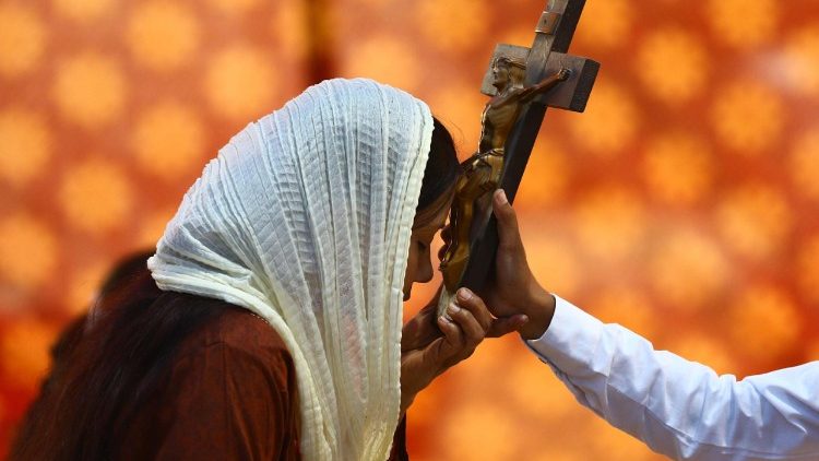Troende kvinna ber under Långfredagen i Pakistan 