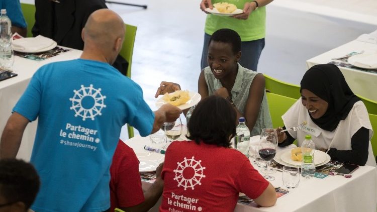 Migrants et bénévoles de la Caritas italienne partagent un repas dans un local de la gare centrale de Rome, le 19 juin 2018.