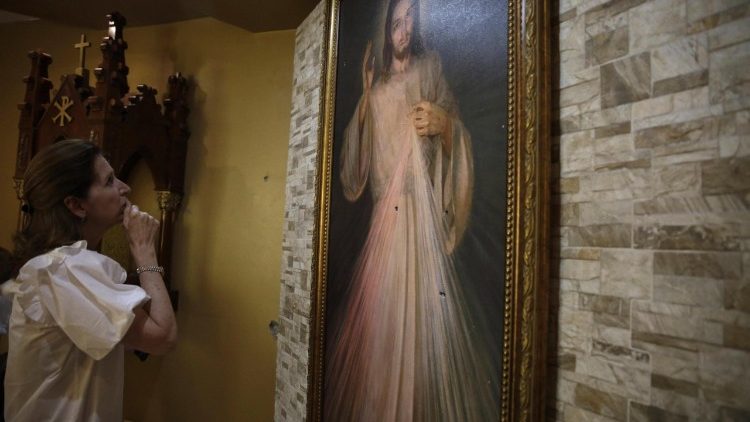 Managua, una donna prega davanti all'immagine di Gesù Misericordioso
