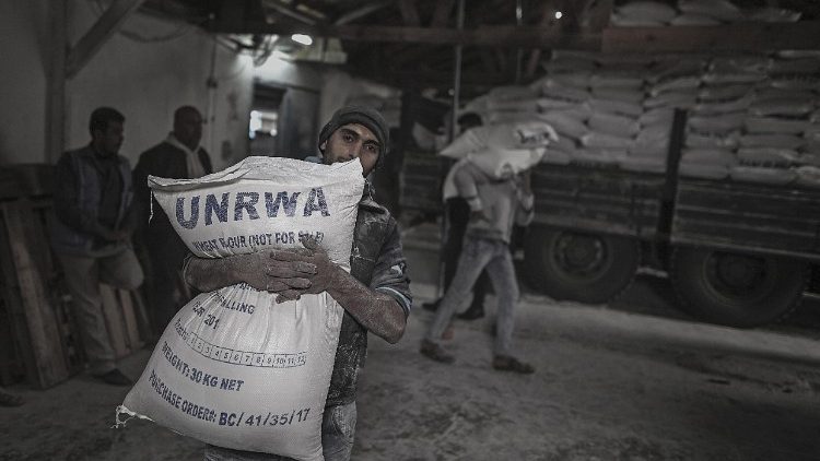 This file photo shows a Palestinian refugee carrying a UNRWA sack of flour