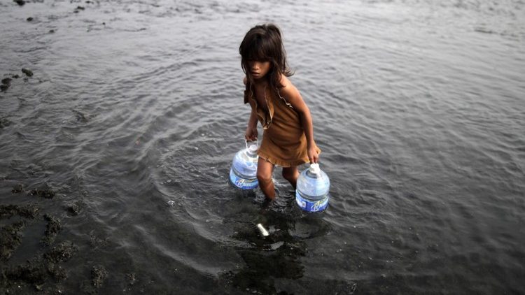 पानी का जार लेकर आती एक बच्ची