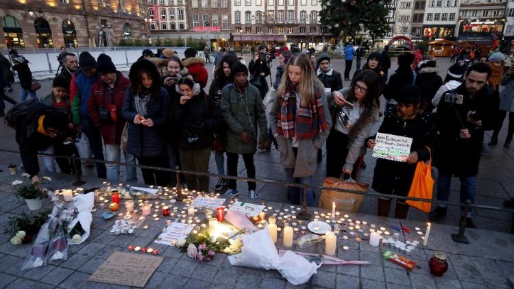 Des personnes déposent des bougies et des fleurs sur le marché de Noël de Strasbourg, à la mémoire des victimes de l'attaque du 11 décembre.