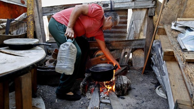 Poverty has driven millions of Venezuelans to desperation. In this photo a man, who cannot afford to pay rent, cooks in a parking lot in Caracas 