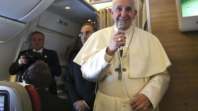Pope Francis speaks to reporters aboard a plane