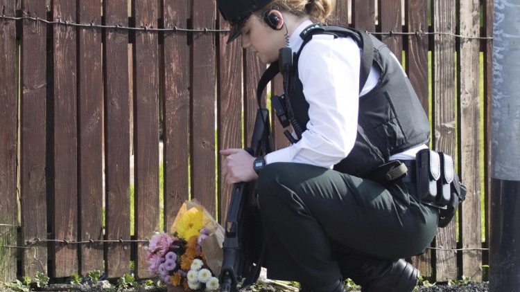Une policière déposant des fleurs sur le lieu de l'assassinat de Lyra McKee, le 19 avril 2019 à Derry.