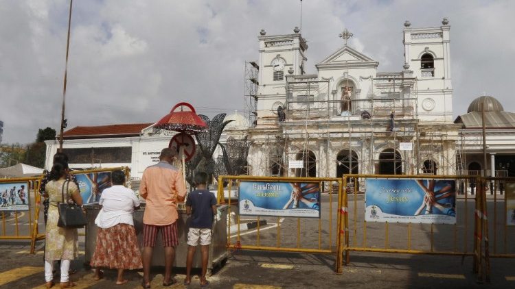 斯里蘭卡信友佇立於遭襲擊的聖堂前