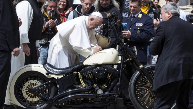 El Papa Francisco firma sobre asiento de una moto Harley Davidson  de los miembros del grupo de motociclistas Cristianos  (Photo by Andreas SOLARO / AFP)