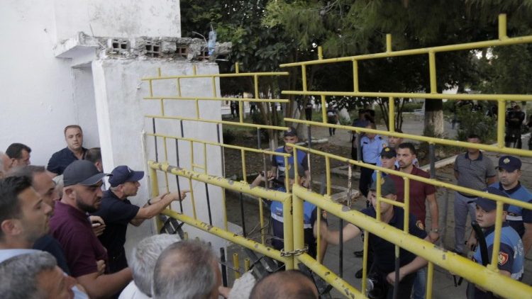 Des opposants albanais devant les grilles d'une école à Kavaje, le 19 juin dernier