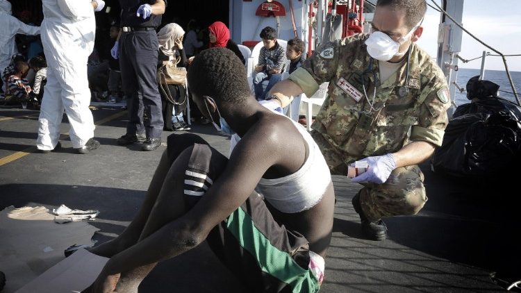Ein Arzt des Roten Kreuzes untersucht einen Migranten an Bord eines Flüchtlingsschiffes
