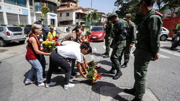 Menschen legen im Gedenken an den verstorbenen Kapitän Blumen vor dem Quartier der Marine in Caracas nieder