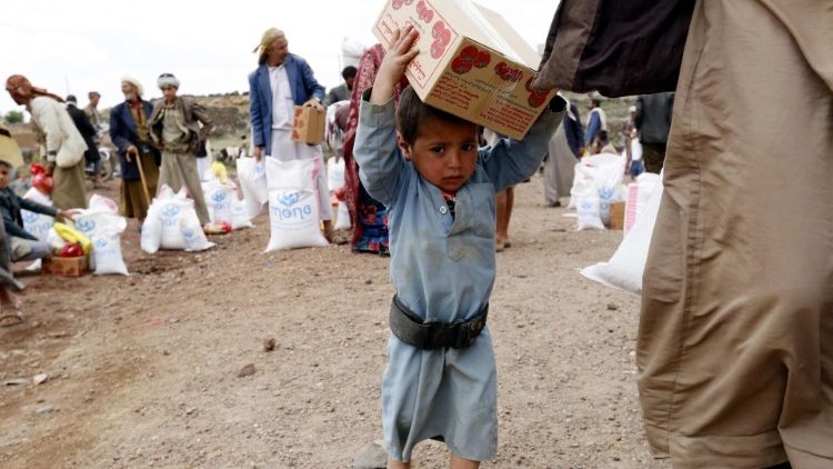 Criança iemenita carrega caixa com alimentos na periferia de Sana'a
