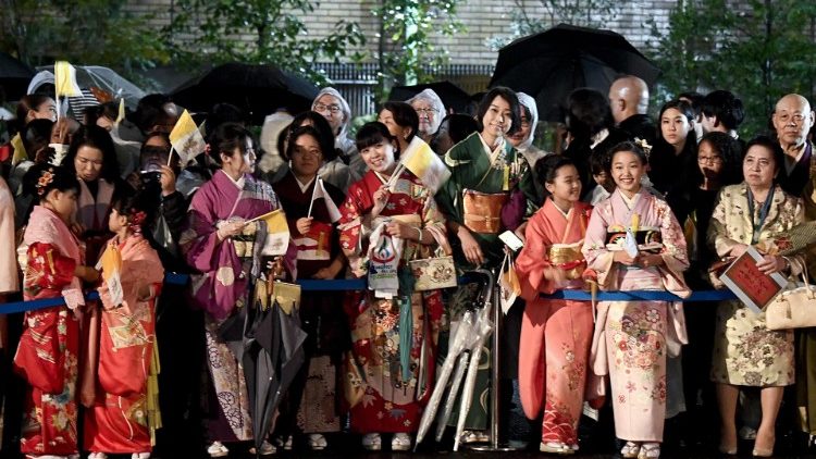 Tradicionális ruhába öltözött hívek várják Ferenc pápát a tokiói apostoli nunciatúra előtt