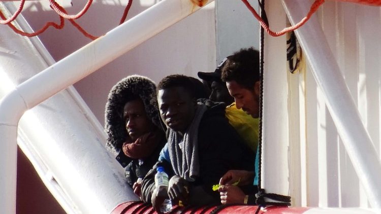 North African migrants waiting to disembark from a rescue vessel in the southern Italian city of Taranto