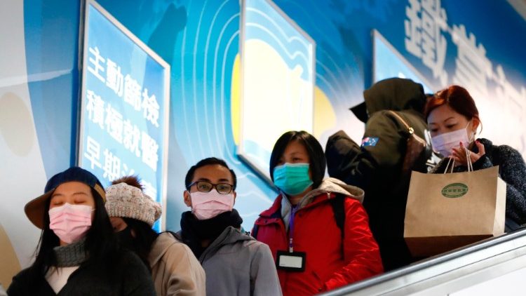Pendolari di Taiwan che indossano mascherine protettive