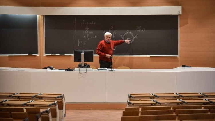 An Italian Professor holds an online lecture in an empty classroom