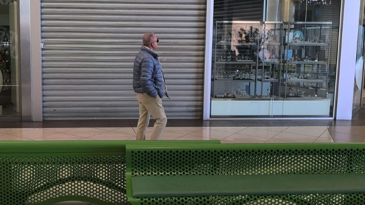 A man walks past closed shops in a mall in Padua