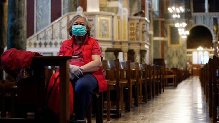 A worshipper wearing a face mask in an empty Westminster Cathedral