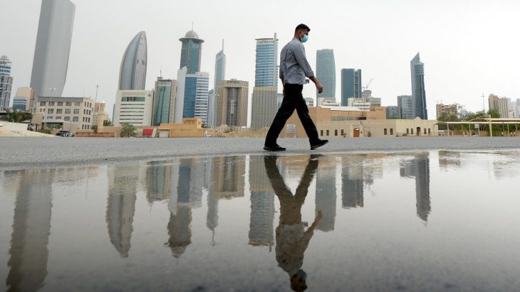 Homem protegido com máscara caminha em Kuwait City.  O país tem 142 casos