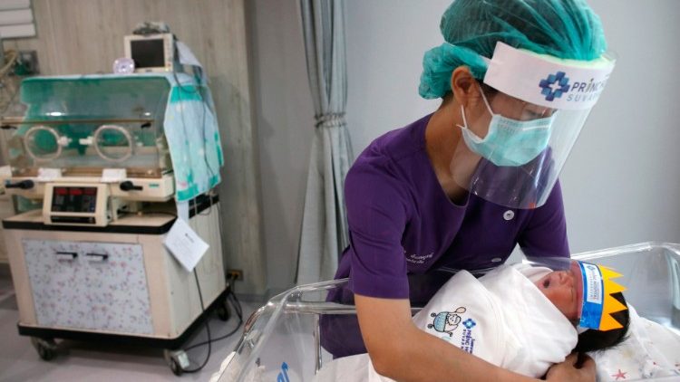 Una enfermera cuida delicadamente a un recién nacido, en un hospital de Tailandia.