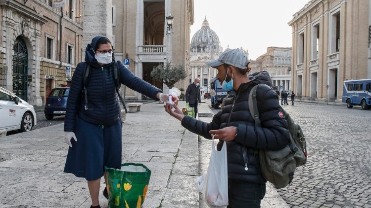 Une religieuse offrant un cadeau à un homme sans-abri près du Vatican à la veille de Pâques, le 11 avril 2020.