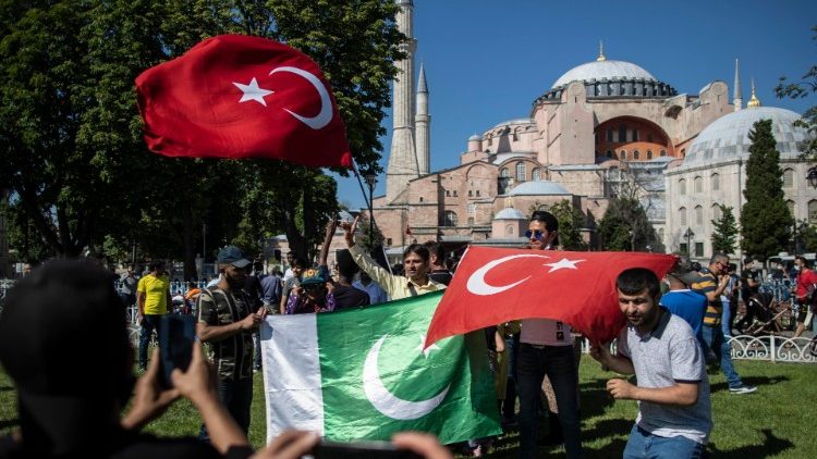 Lidé s tureckými a pákistánskými vlajkami oslavují rozhodnutí umožňující přeměnu Hagia Sophia na mešitu