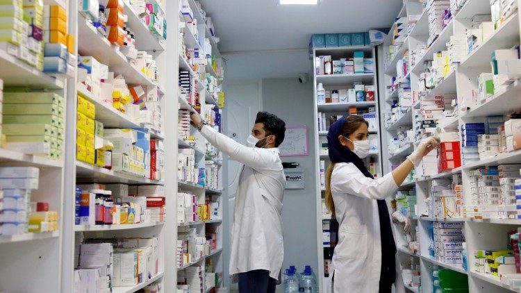 Iranian pharmacists stock shelves at a drugstore in Tehran