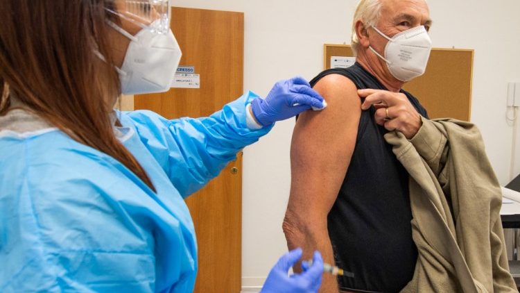 Un medico durante la vaccinazione a un paziente
