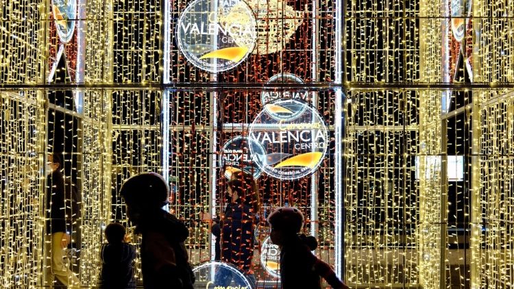 Los niños juegan bajo las instalaciones de luces navideñas en Valencia, España, el 20 de diciembre de 2020. 