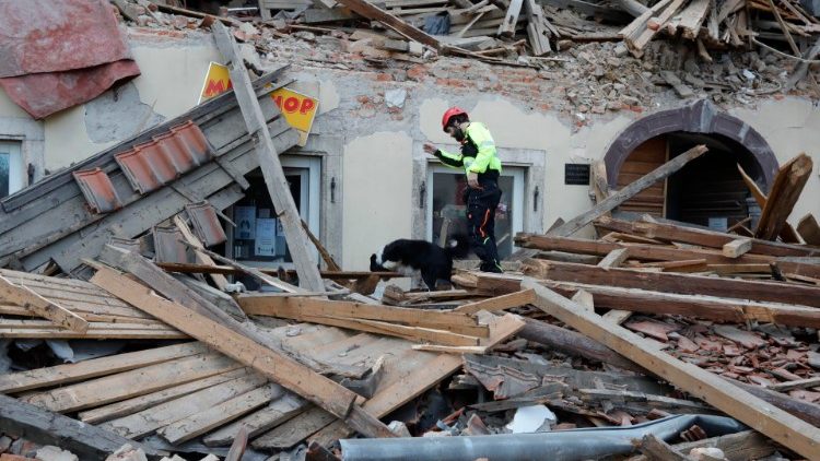 Socorrista com cão farejador procura sobreviventes sob os escombros de casa em Petrinja