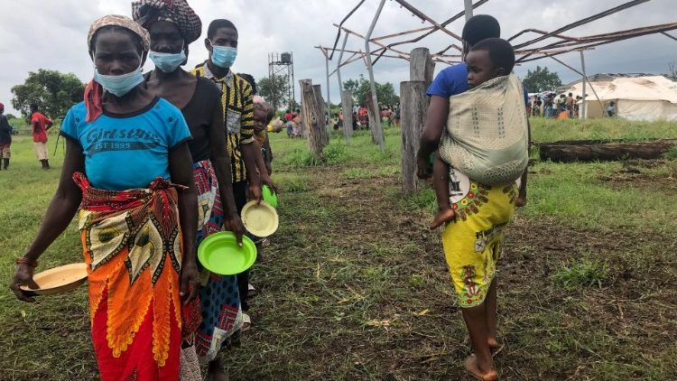 Personas hacen cola para recibir comida en el centro de alojamiento de Tica, después de que sus aldeas se inundaran el pasado fin de semana debido al paso del ciclón Eloise, en el distrito de Nhamatanda, en el centro de Mozambique, el 25 de enero de 2021.