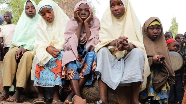 Mädchen, die vor Bewaffneten geflohen sind, warten vor dem Schulgelände auf ihre Eltern, nachdem Bewaffnete mehrere hundert 300 Schülerinnen entführt haben.