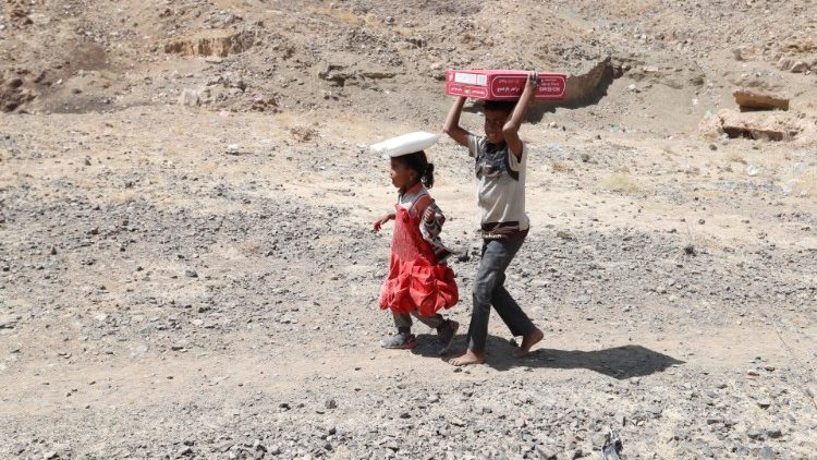 Los pequeños desplazados yemeníes ayudan a llevar  raciones de comida 