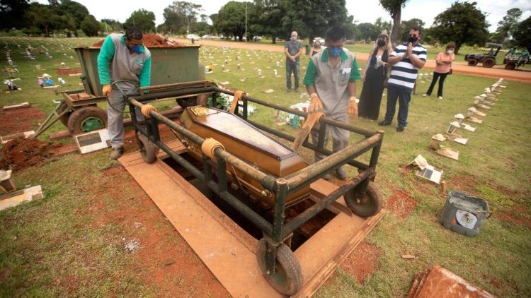 Des familles assistent à l'enterrement de leur proche décédé de la Covid, dans le cimetière de Campo da Esperanza à Brasilia, le 11 mars 2021.