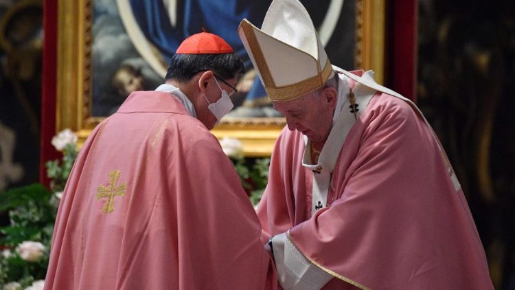 Pope Francis speaks to Cardinal Luis Antonio Tagle after Mass in St. Peter's