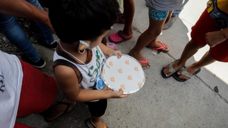 Ein Kind erhält in einer Favela in Sao Paulo eine gespendete Mahlzeit