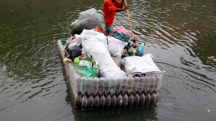 Philippinischer Fischer in einem Boot aus Plastikflaschen