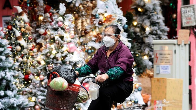 Hanoi: eine Radlerin fährt an Shop mit Weihnachtsdekorationen vorbei