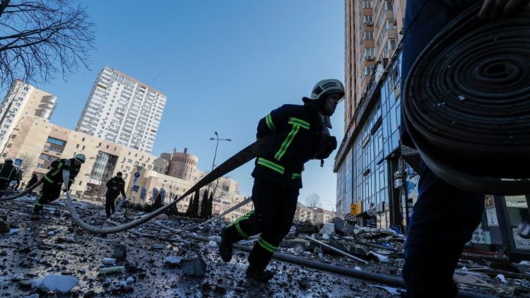 Feuerwehrleute versuchen, das Feuer zu löschen, das durch den Beschuss in einem Apartmentgebäude in Kiew ausgebrochen ist