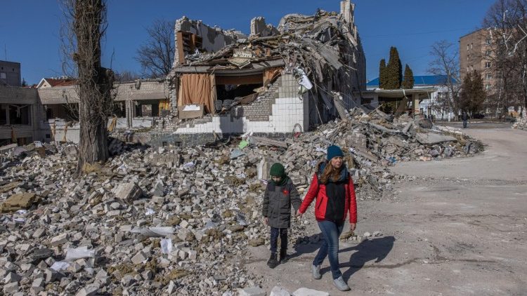 Ucraniana com seu filho em meio aos destroços de uma escola destruída por bombardeios russos em Zhytomyr, Ucrânia. EPA/Roman Pilipey