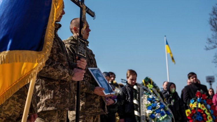 यूक्रेन में सैनिक एक दफन क्रिया में भाग लेते हुए