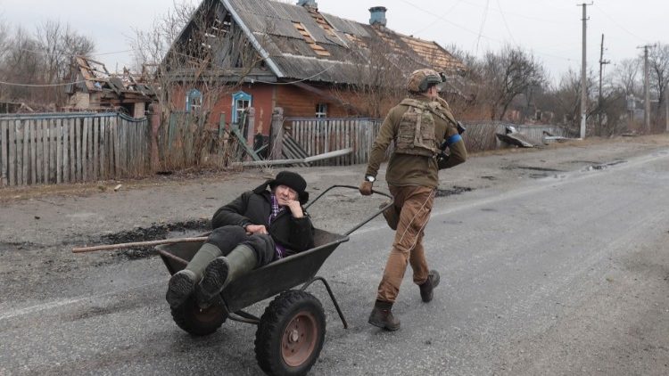 Soldado ucraniano evacua Valentyn Vasylenko (83) de sua casa danificada na vila de Teteriv, não muito longe de Kiev (Kiev), Ucrânia, 31 de março de 2022. EPA/STR