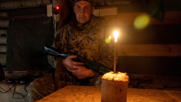 A Ukrainian soldier sits in a Kharkiv shelter with an Easter Cake