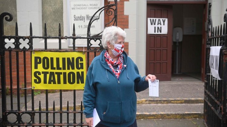 Una donna distribuisce volantini a sostegno del partito TUV (Traditional Unionist Voice)
