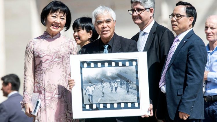 NIck Ut (C), holding his Pulitzer Prize-winning photo, and Kim Phúc Pahn Thi (L) at Wednesday's General Audience.